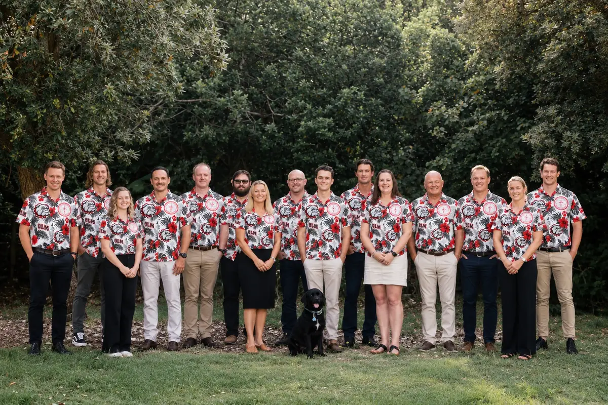 Company team in red floral shirts on a lawn