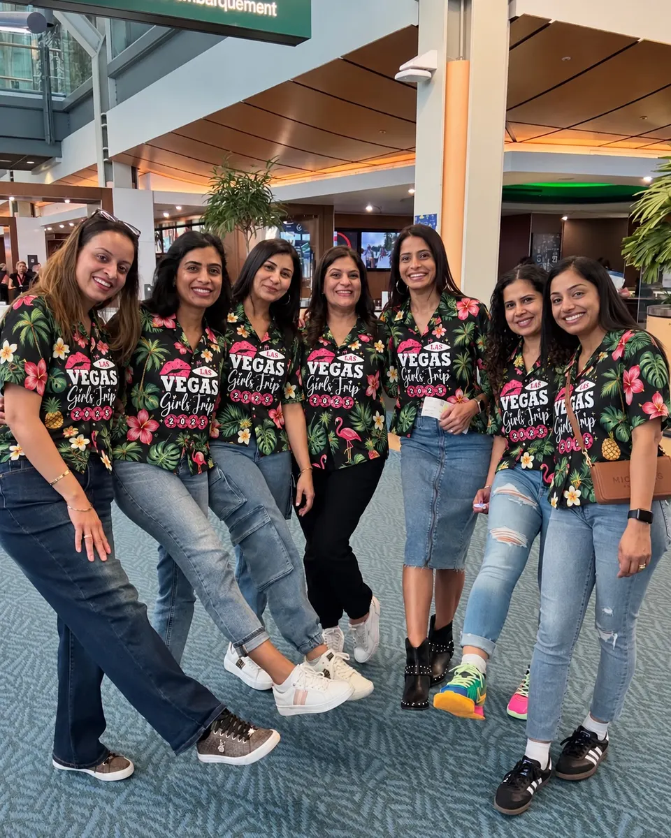 A group of friends in matching black floral shirts printed with their trip name