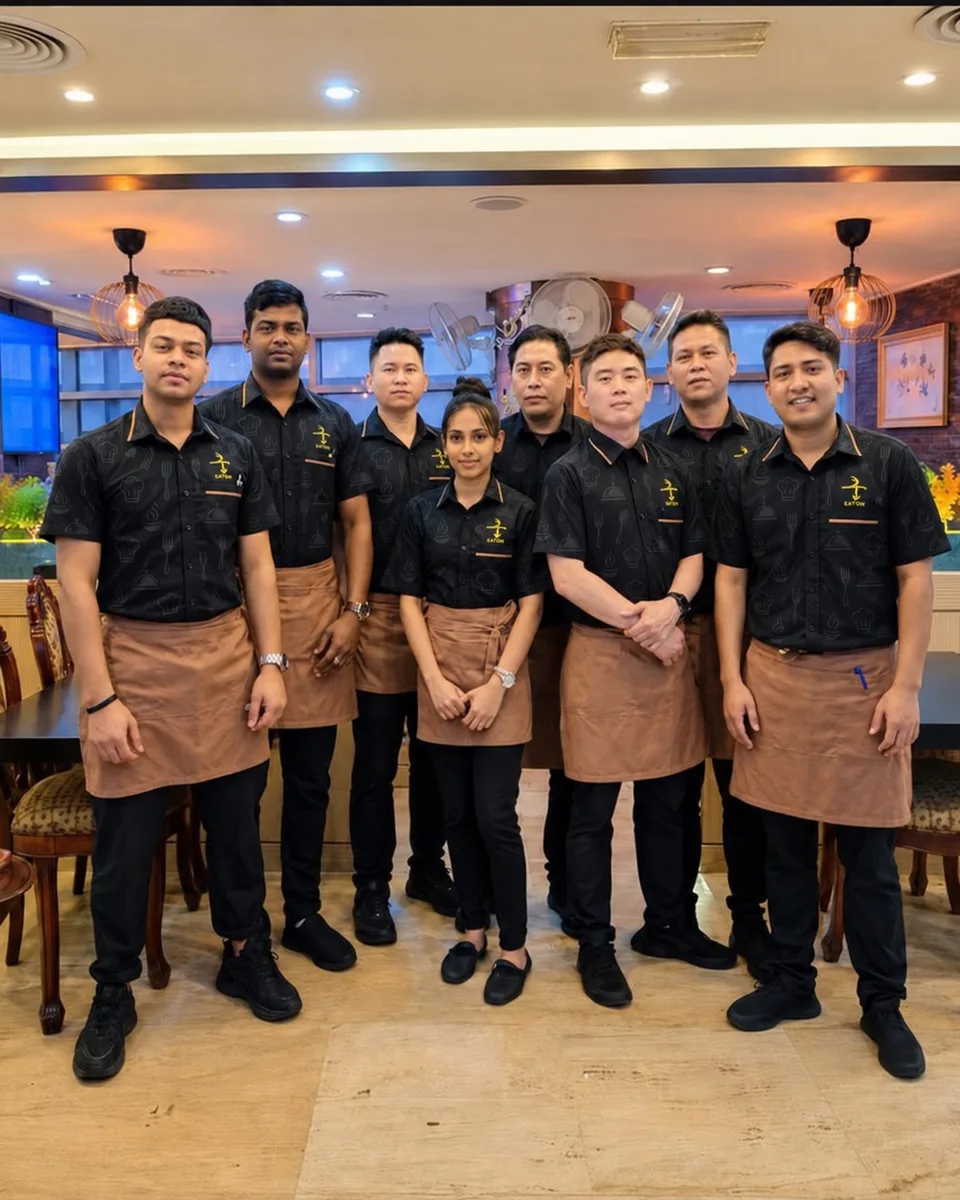 Restaurant staff in black shirts and aprons