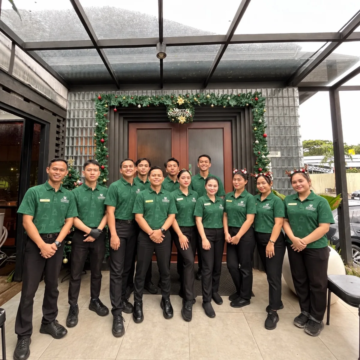 Restaurant staff in matching green uniform shirts